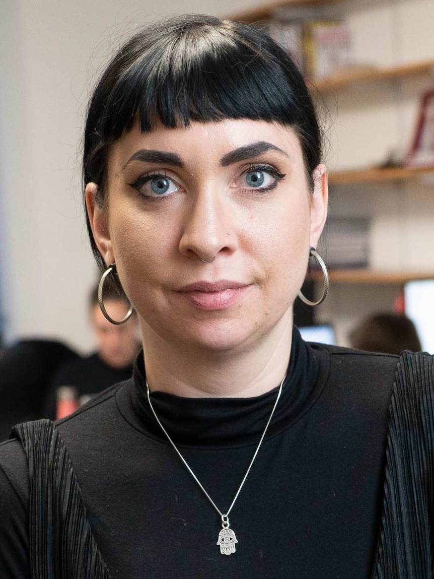 A dark-haired woman poses for the camera.