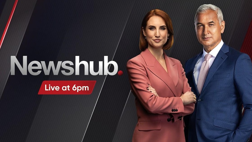 A Newshub advert with two news presenters on it. One female in a pink suit and one male in a blue suit.