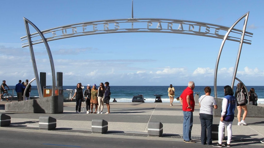 Tourists pose under the Surfers Paradise sign