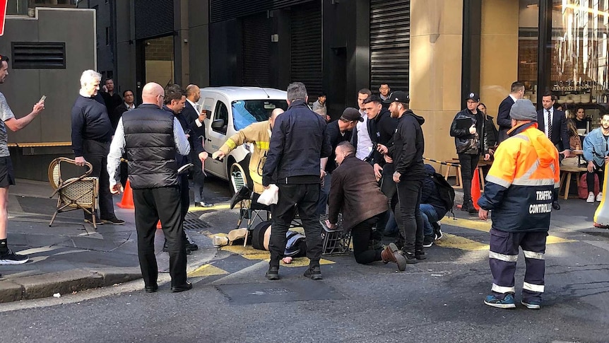 Members of the public are seen holding a suspect down in the middle of a Sydney street.