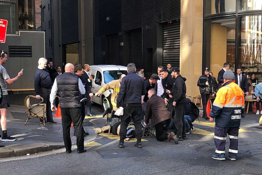 Members of the public are seen holding a suspect down in the middle of a Sydney street.