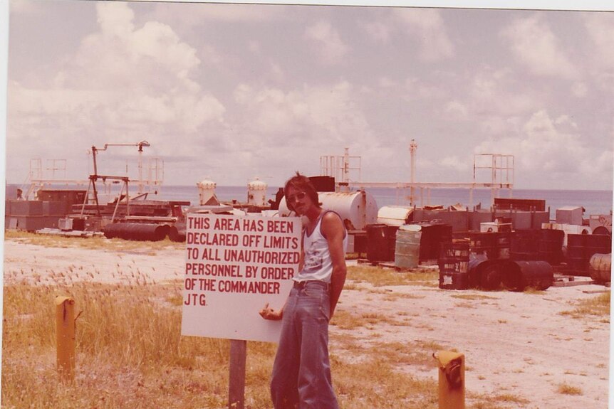 Ken Kasik stands in front of a sign that says "this area has been declared off limits to all unauthorised personnel".