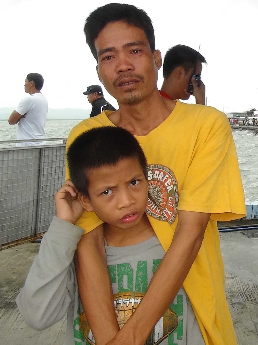 Rescued 10-year-old passenger Gilbert de la Cruz is reunited with his father Bano