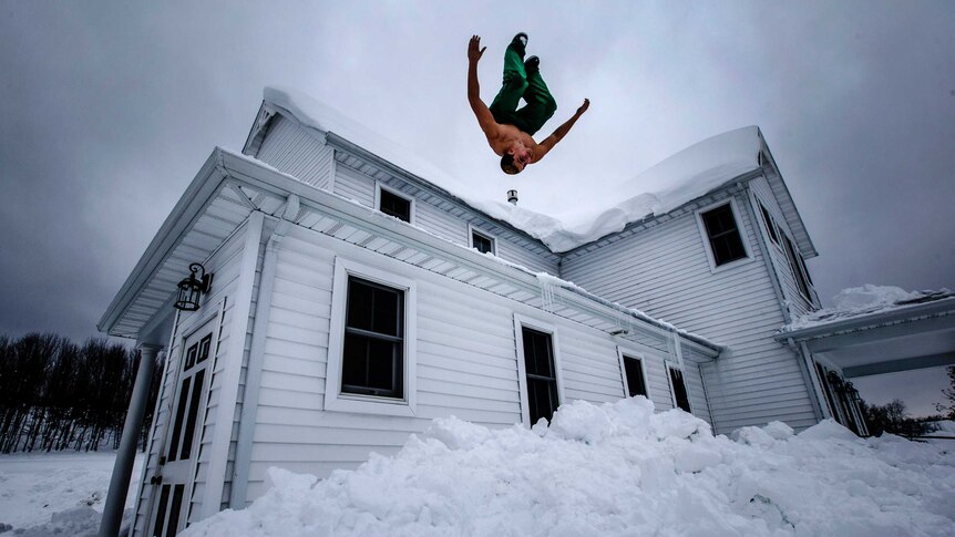 Phil Mohun does a back flip off of his family home after clearing snow from the roof following the snowstorm in Cowlesville, New York.