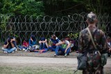 A Hungarian soldier guards asylum seekers