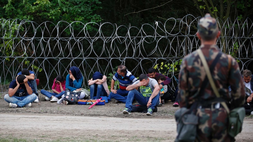 A Hungarian soldier guards asylum seekers