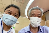 Singapore's Prime Minister Lee Hsien Loong takes a selfie with the nurse who vaccinated him against COVID