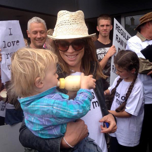 Baby drinks raw milk from bottle at raw milk protest in Melbourne