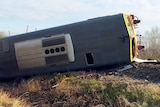 A train carriage lies on its side