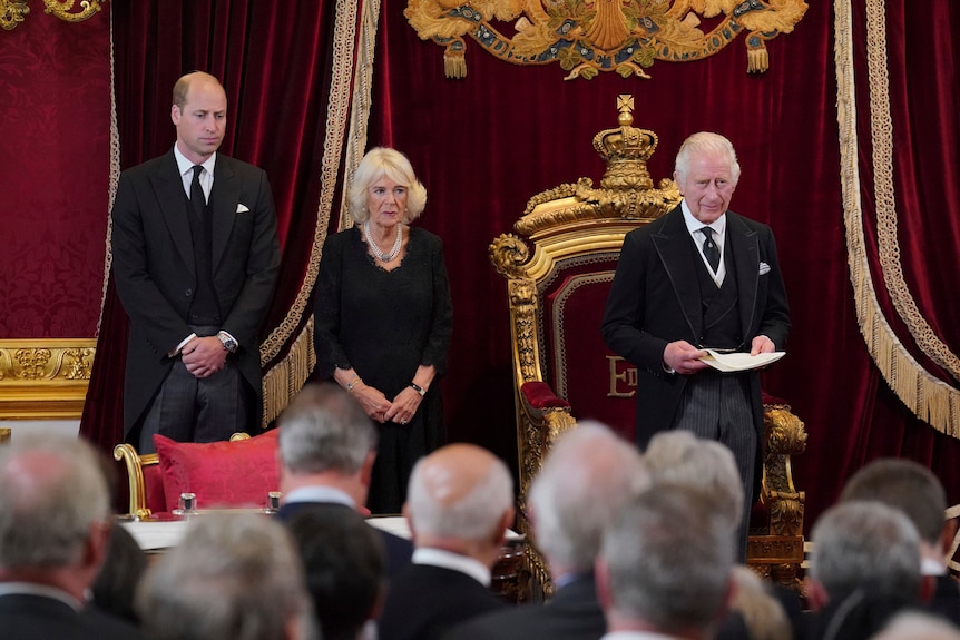 윌리엄 왕자, 카밀라 왕, 찰스 3세 왕이 화려한 왕좌 앞에 서 있습니다. 