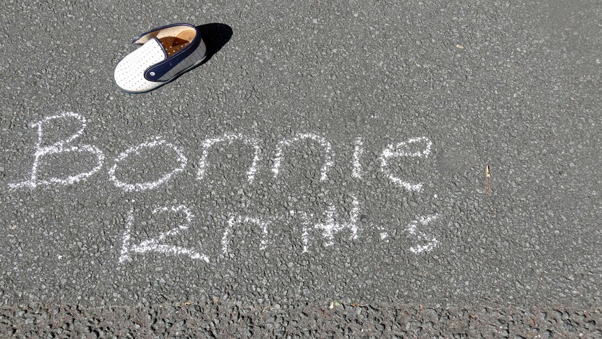 Baby's shoe on a footpath with words Bonnie next to it.