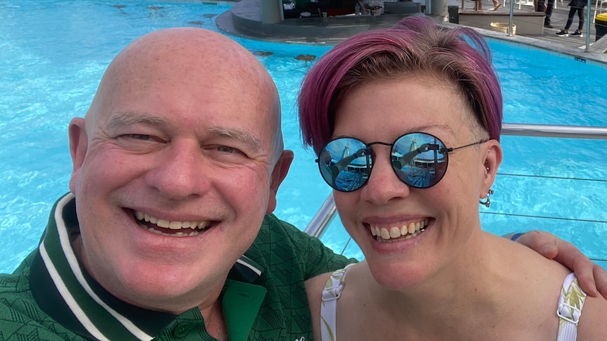 Max Winchester and his wife Tiffany smile and pose together for a selfie in front of a pool.