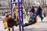 Three men exercise using a seniors' playground.