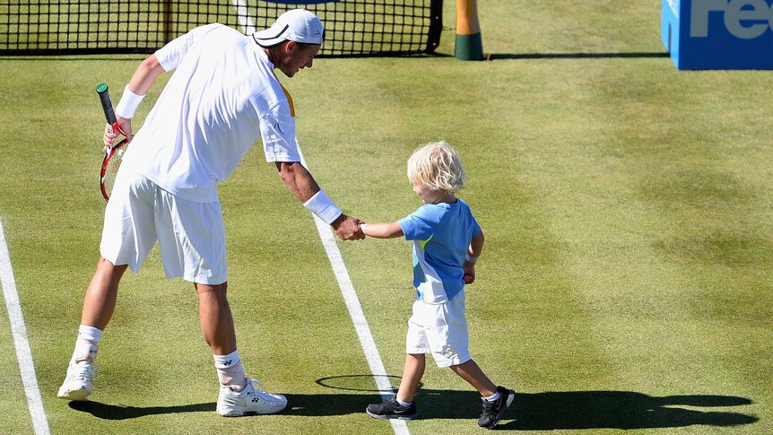Australia's Lleyton Hewitt celebrates victory with his son Cruz at Queen's Club.