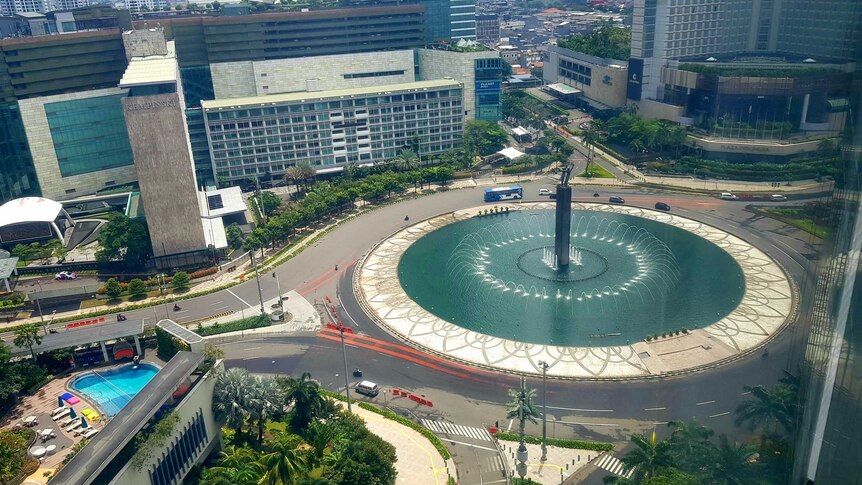 High view of fountain in CBD surrounded by roads with very little traffic.