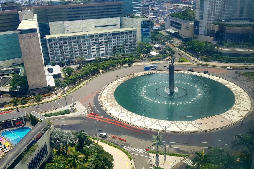 High view of fountain in CBD surrounded by roads with very little traffic.