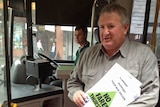 Unions Tasmania secretary Kevin Harkins boards a Metro bus in Hobart.