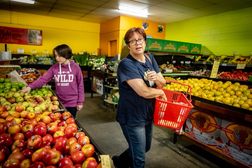 A young girl and a mum shopping for fruit.