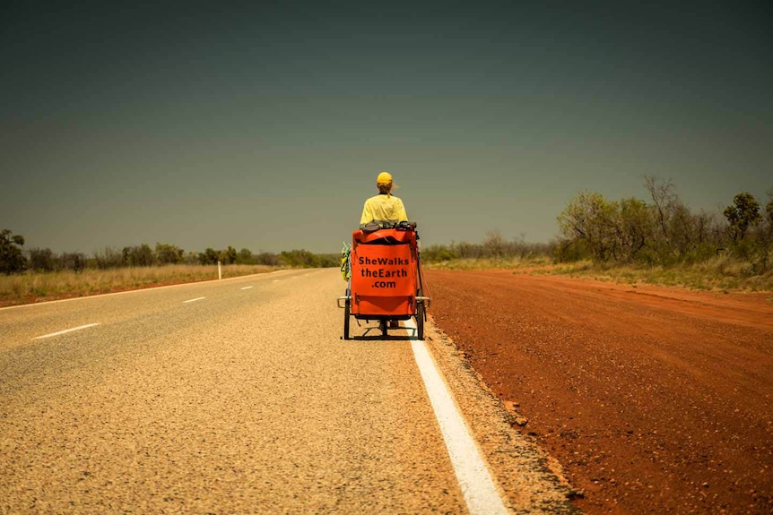 Angela Maxwell pulling her rickshaw pram along the road