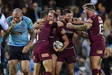 Cameron Smith hugs Cooper Cronk with team-mates around after Queensland won State of Origin III.