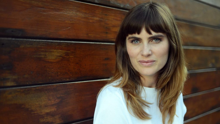 Borderline Personality Disorder patient Beth McMullen stands next to a wall.