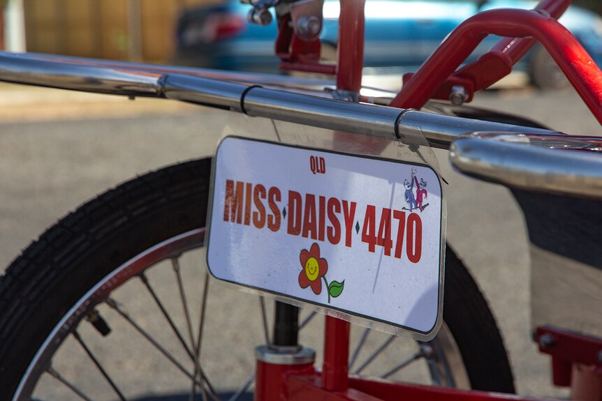 A license plate on the bike reads 'miss Daisy'