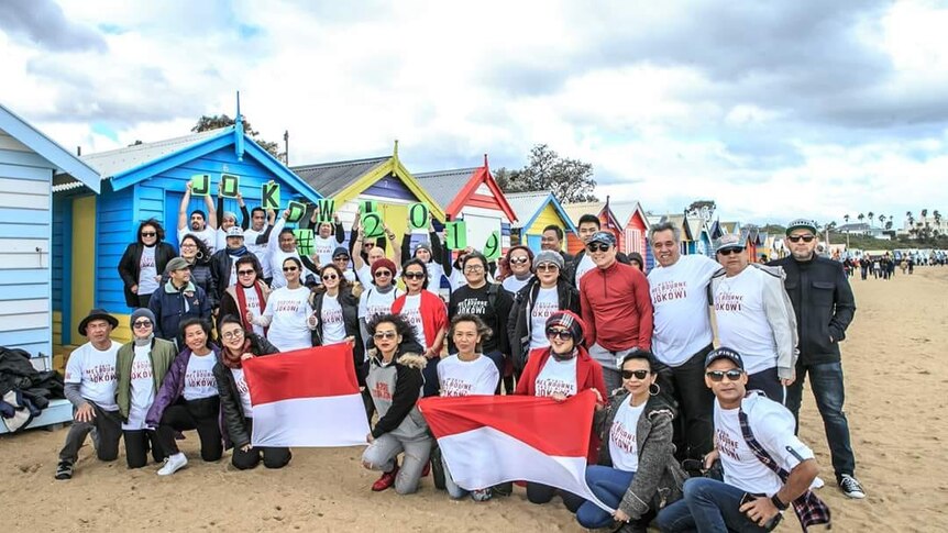 A group of people taking photo in a beach of Melbourne