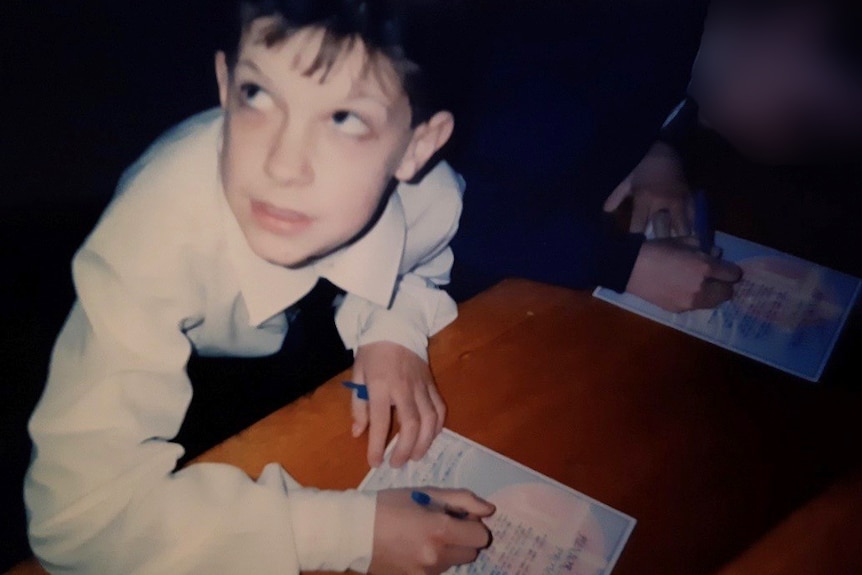 A boy signs a document.