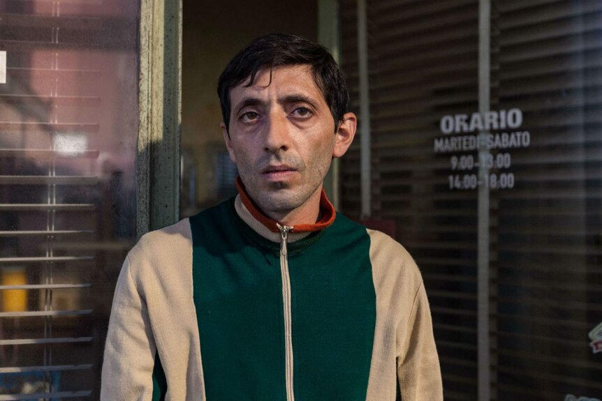 Wearing a battered and tired looking windbreaker, the actor stares desolately into the camera.
