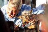 A man gestures towards the dog which won this year's World's Ugliest Dog Contest.
