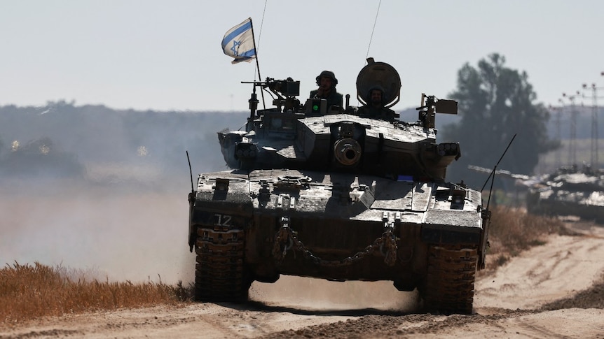 A tank with an Israeli flag on it, driving on a dirt road