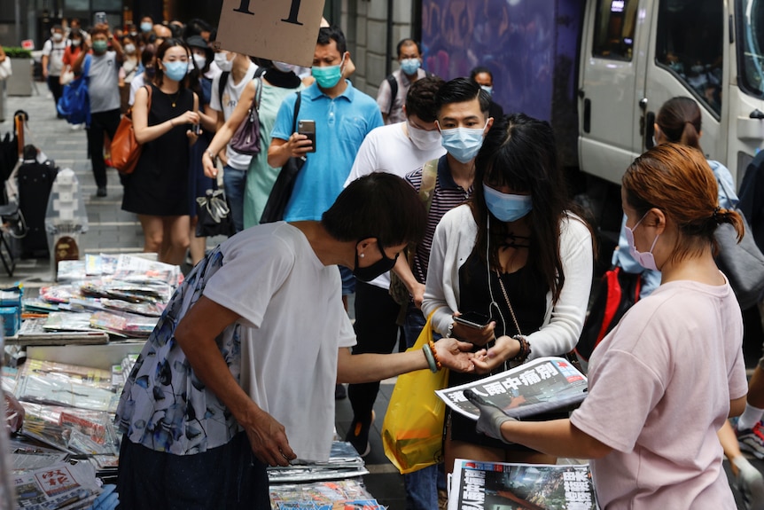 人们排队购买《苹果日报》。