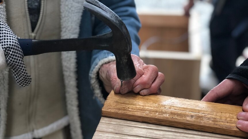 Close up of a woman's hands hammering a nail