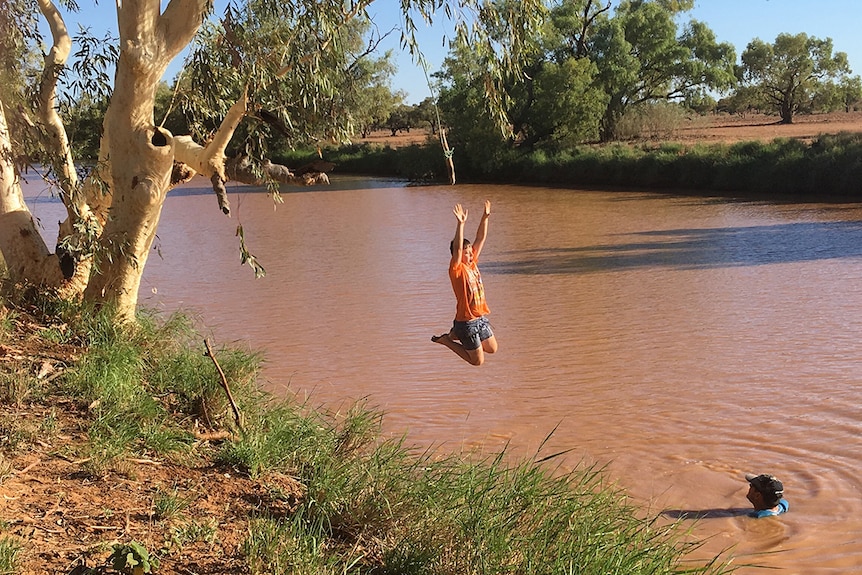A child jumps into a waterhole on a summer day at Boulia in western Queensland.