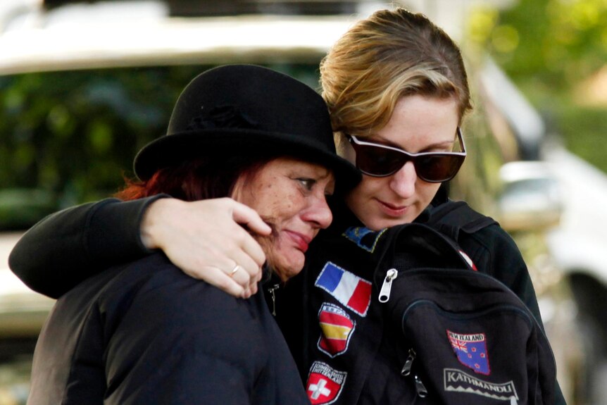 Two women hug at a memorial service to mark the first anniversary of the Christchurch earthquake.
