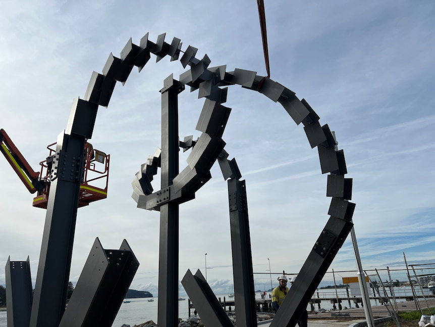 Sculpture near a bridge with sky in background 