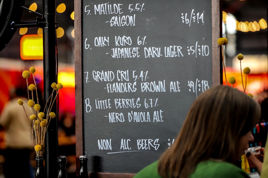 Blackboard with white chalk writing listing a series of craft beers