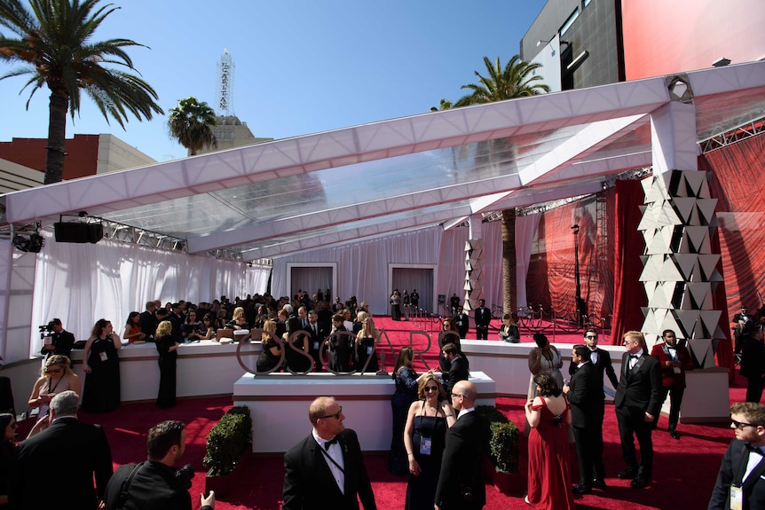 A white-curtained area with two entrances, one with black crowd-control ropes.