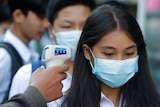 A female students has her temperature checked in Phnom Penh, Cambodia.
