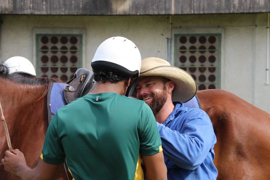 Marc Gallagher helps one of the students put a helmet on.