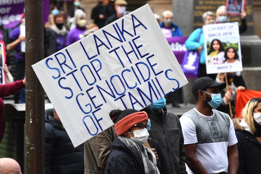 A person holds a placard reading 'Sri Lanka stop the genocide of Tamils' at a rally in Melbourne