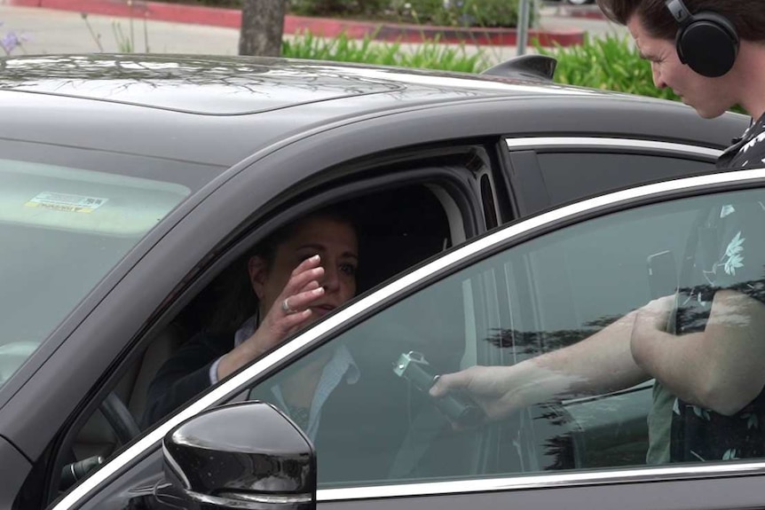 A woman being interviewed makes a gesture with her hands.