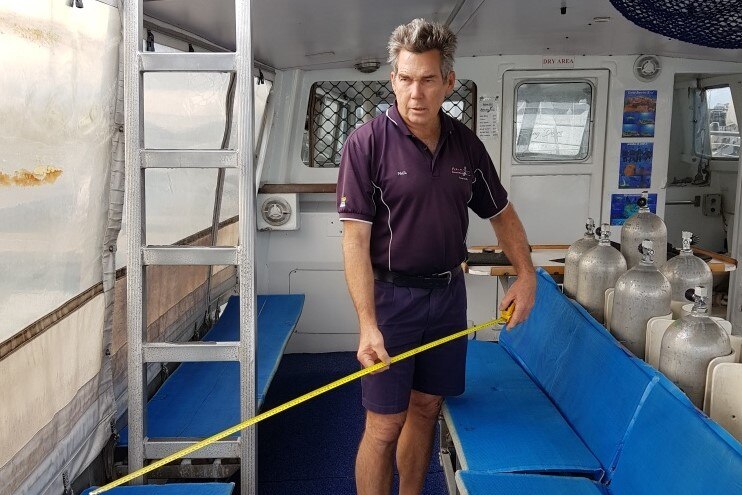 A man stands on a dive boat.