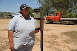 Jenny Gordon checks the rain gauge on El Kantara Station with a red truck in the background