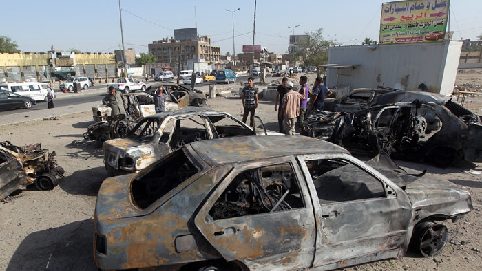 Residents inspect the aftermath of a car bombing in a Shiite district of Baghdad on July 2.