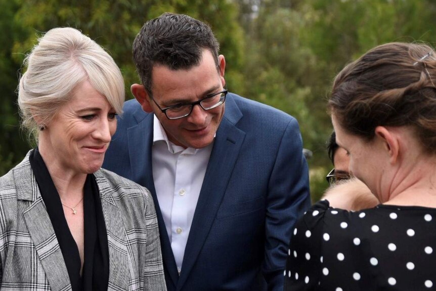 Daniel Andrews and his wife Catherine engage with a baby being held by a woman.
