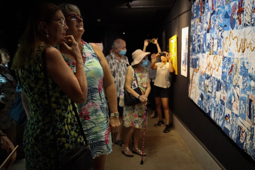 Women who stitched pieces searched for them at the community quilt launch.