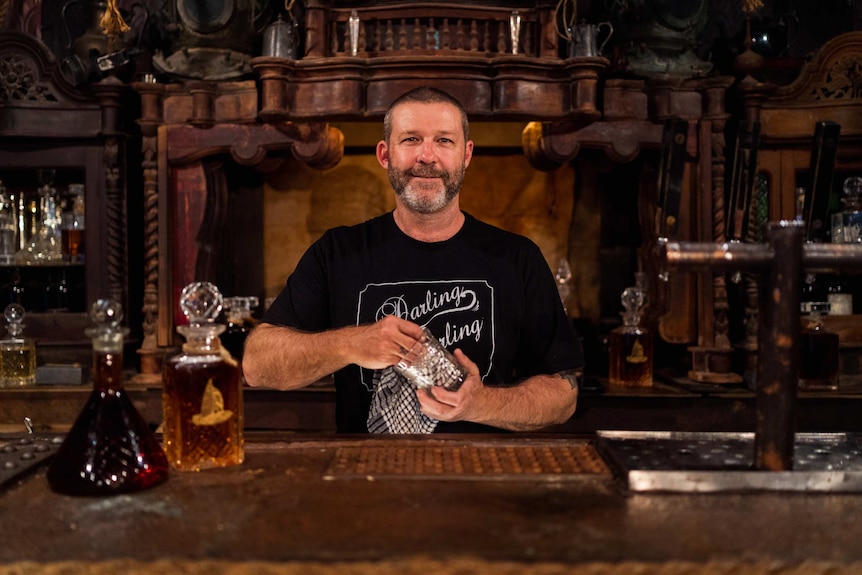 Nigel Sutton standing behind ornate seafarer's bar