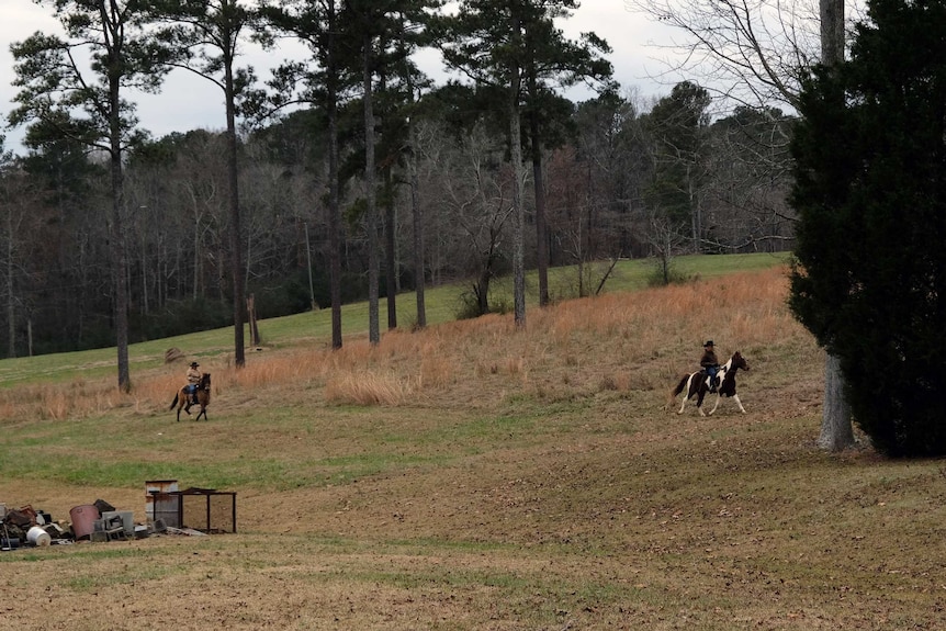 Roy Moore rides his horse across a paddock.