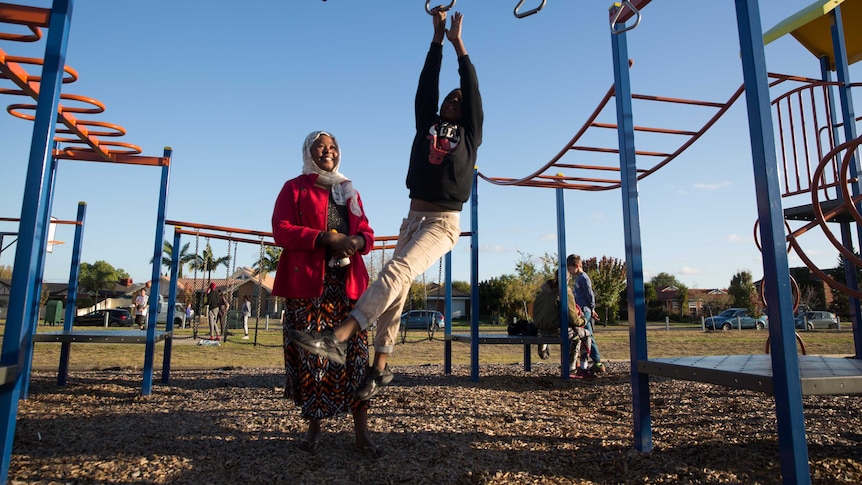 Kadiga supervises her second-youngest son Maher on the monkey bars